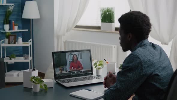 African American Man Remote Worker Working From Home Taking Online Office Call with Partners and