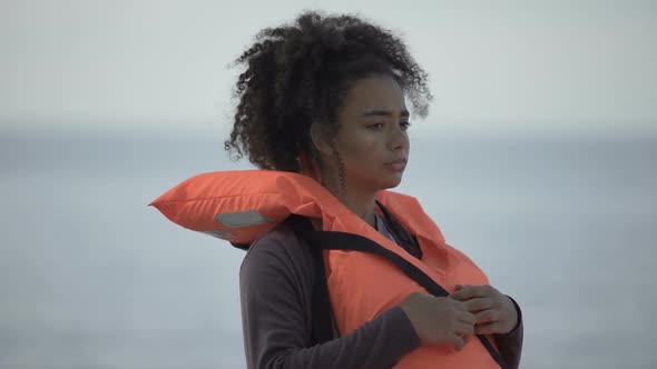 Sad Teenage Girl in Life Jacket Looking Distressed and Lonely, Disaster Victim