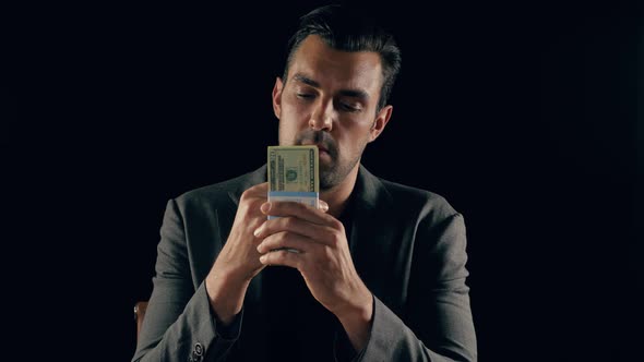 Handsome man plays with a stack of cash