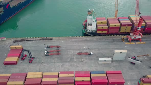 Ship view from a drone. Unloading of containers by a crew and a crane in port