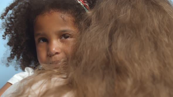 Close Up of Caucasian Mother and Happy Mixed-race Toddle Daughter Hugging.