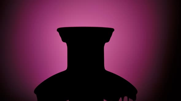 Black Silhouette of a Chocolate Fountain on a Purple Background