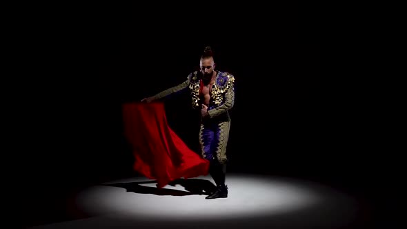 Torero in Blue and Gold Suit or Typical Spanish Bullfighter Isolated Spotlight on a Black Background