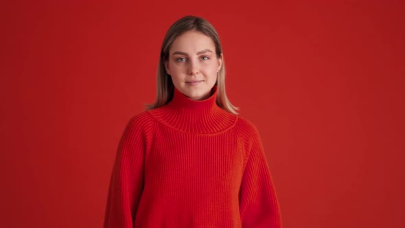 Cheerful woman wearing red sweater showing call me gesture