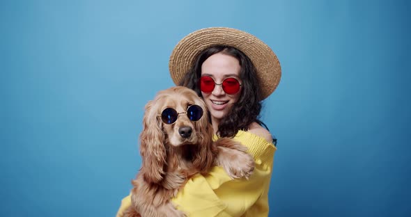 Funny English Cocker Spaniel with Sunglasses Posing with a Woman in Studio