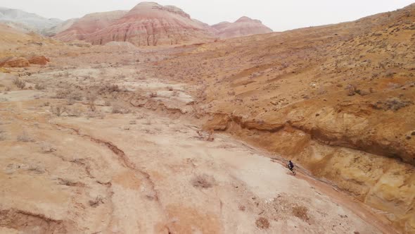 Drone Shot of Bicyclist Ride in Canyon Desert Mountains in Kazakhstan