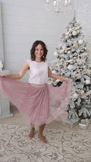 Beautiful Girl Woman Near Christmas Tree Smiling Dancing in Beautiful Dress in Decorated House