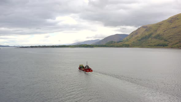 A Commercial Ship is Seen Traversing A Sea Loch in Scotland