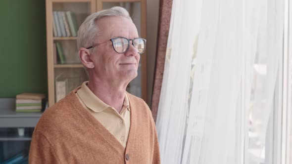 Senior Man Standing by Window