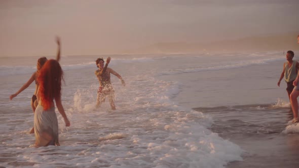 Carefree Young People Having Fun on Beach at Sunset