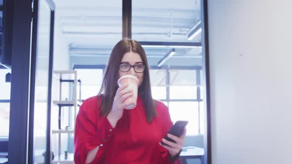 Businesswoman drinking coffee in modern office