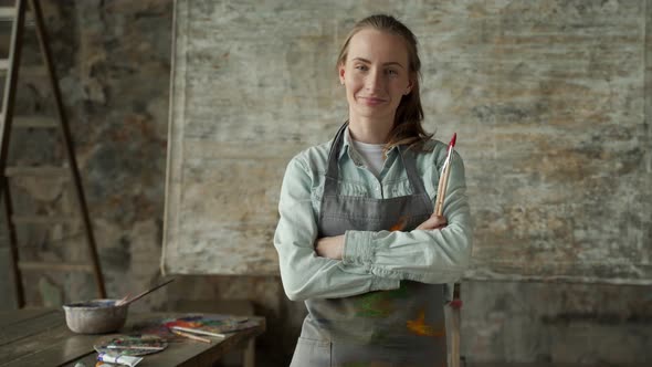 Portrait Happy Woman Artist Wearing Apron Looking at Camera and Smiling While Standing in Her Art