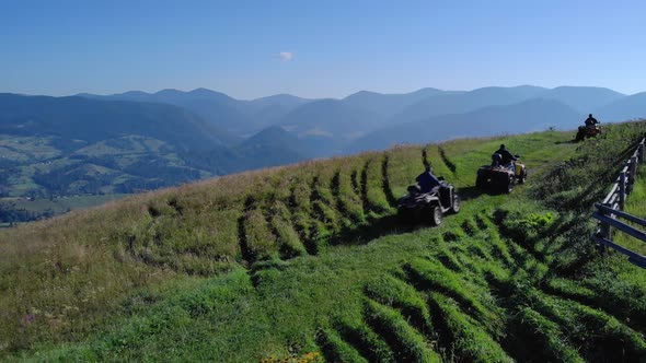 Men Riding Quad Bikes on Mountains Background