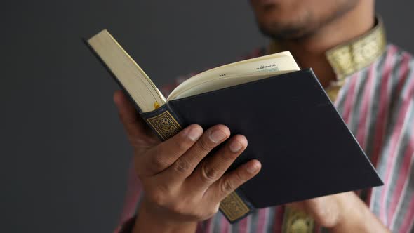 Muslim Man Hand Holding Holy Book Quran with Copy Space