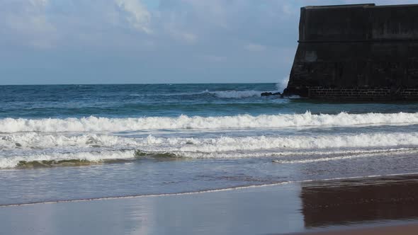 Castle on the Coast. Castle Rock Beach, Carcavelos, Lisbon. Waves breaking on the shore