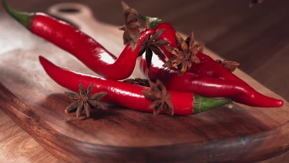 Red Chilli Pepper and Anise Falling Down on Wood