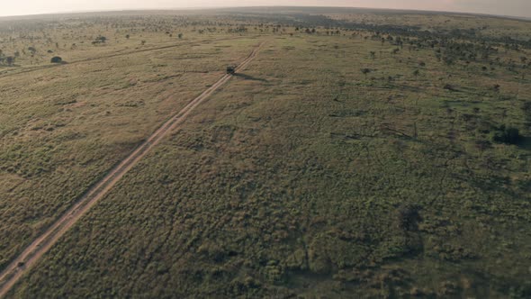 4 wheel drive vehicle on wildlife safari in Kenya. Aerial drone reveal of safari adventure