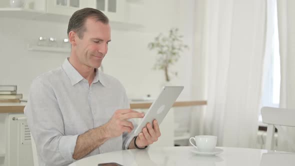 Middle Aged Man Using Tablet at Home