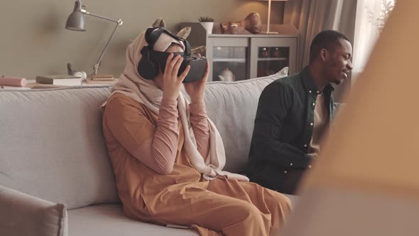 Muslim Woman Experiencing Virtual Reality at Home