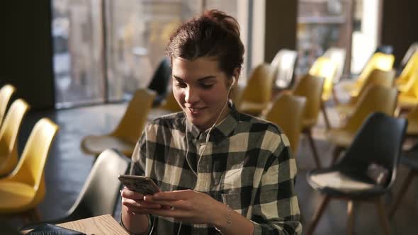 Handsome Guy Sits Right Next to an Attractive Brunette Girl in Black'n'white Check Shirt