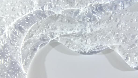 Transparent Cosmetic Gel Fluid Flowing Down on a White Surface