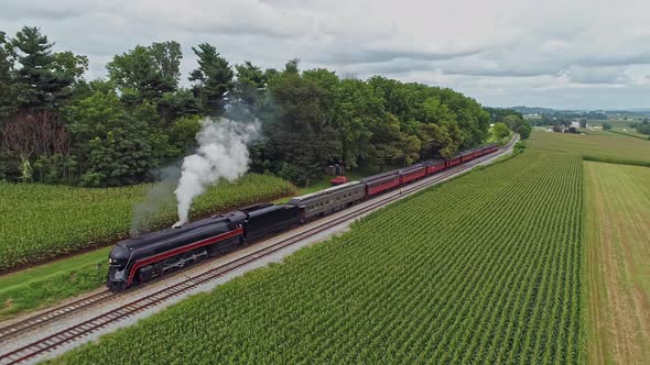 Aerial View, Traveling In Front of An Antique Steam Passenger Train, Blowing Smoke and Traveling Thr