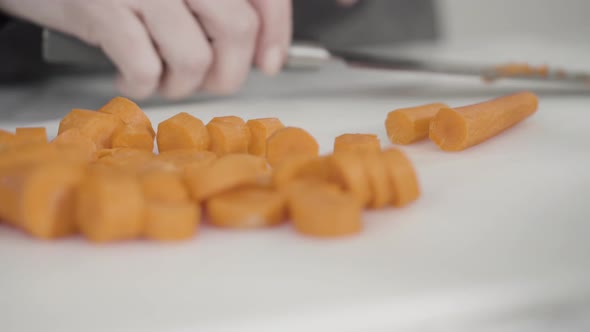 Curring vegetables on a white cutting board to cook vegetarian white bean soup.