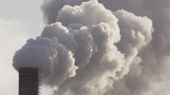 EPIC ZOOM IN to thick billowing smoke from an industrial chimney