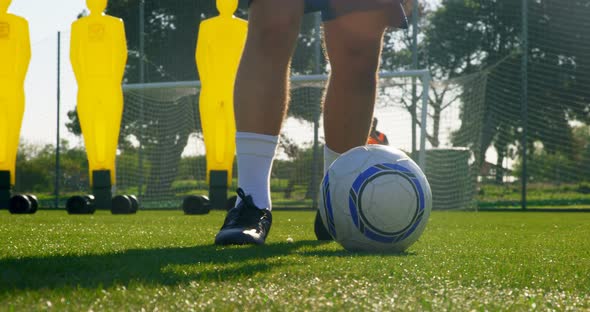 Soccer player kicking the ball toward the goalpost