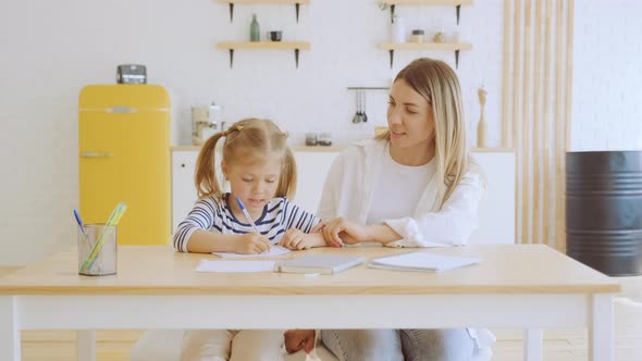 Mother and Her Preschool Daughter Do Homework Together at Home Mom Helps