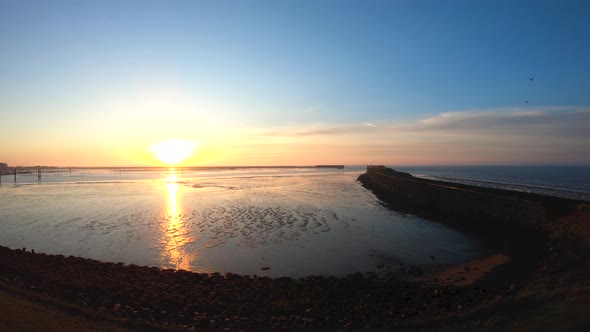 Aerial drone footage bird's eye view at the sunrise by the ocean going from rigt to left