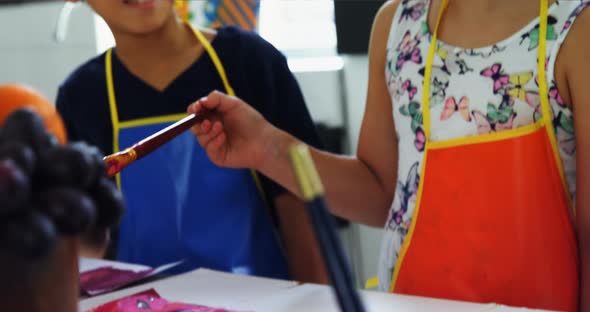 Smiling schoolkids practicing drawing in drawing class