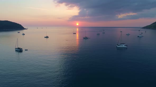 Colorful sunset above the sea surface with sail boats Aerial view drone fly over Phuket sea