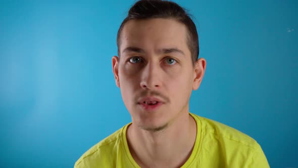 A Young Guy Says the Word No on a Blue Background