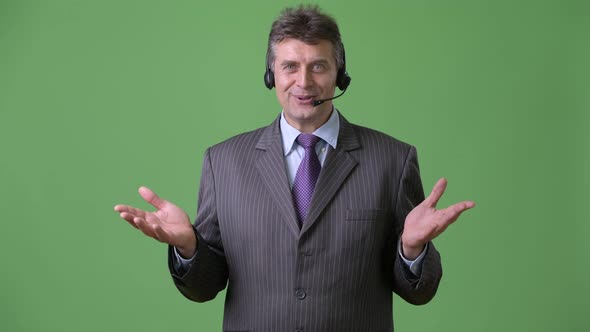 Mature Handsome Businessman Against Green Background