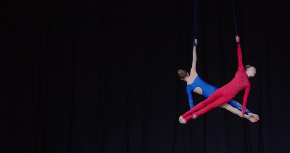 Tournament of Aerial Gymnastics on Stage Two Girls are Spinning Sports