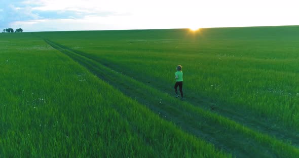 Sporty Child Runs Through a Green Wheat Field