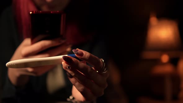 Woman Takes Photos of a Pregnancy Test on Her Smartphone and Smiles