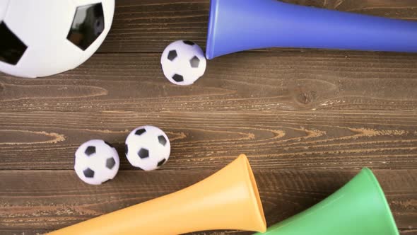 Soccer ball and Vuvuzela stadium horns on a wood background.