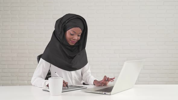 Woman Working on Digital Tablet and Laptop