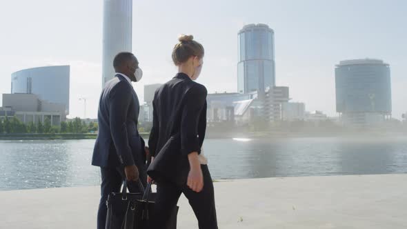 Business Couple Walking And Talking Near River