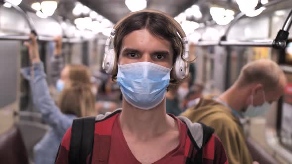Portrait of Masked Man in Headphones in Metro Car