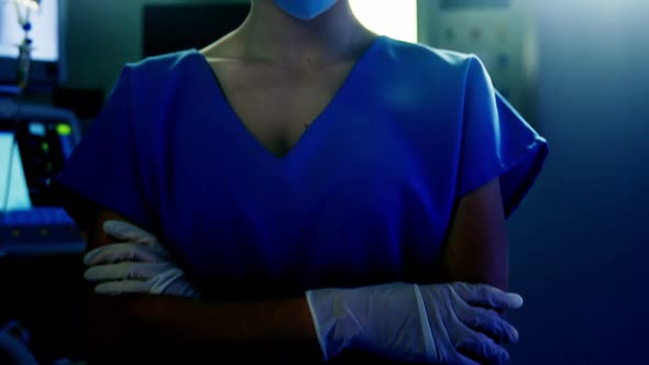 Portrait of female surgeon standing with arms crossed in operating room