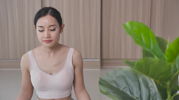 Girl practicing yoga breathing with eyes closed and meditating on the background
