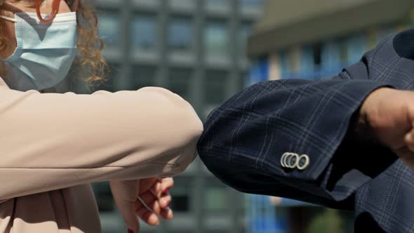 Man and Woman Bumping Elbows to Say Hello Outdoors