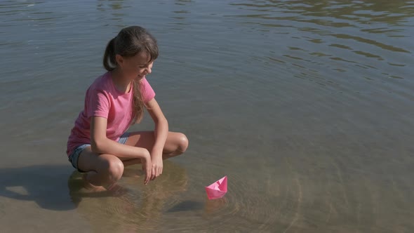 A child with a paper boat.