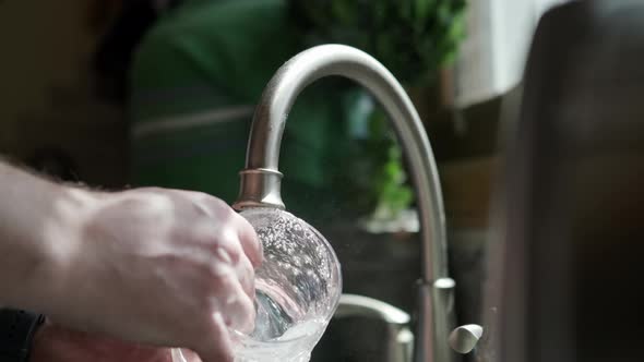 Close Up View of Hands in Orange Gloves Wash Dishes in the Kitchen