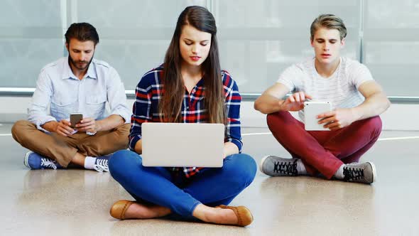 Team of executives using mobile phone, laptop and digital tablet