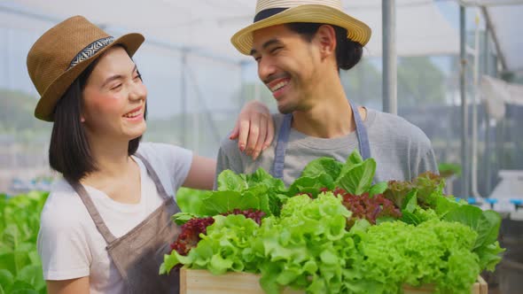 Asian couple farmers owner working in vegetables hydroponic farm with happiness and look at camera.