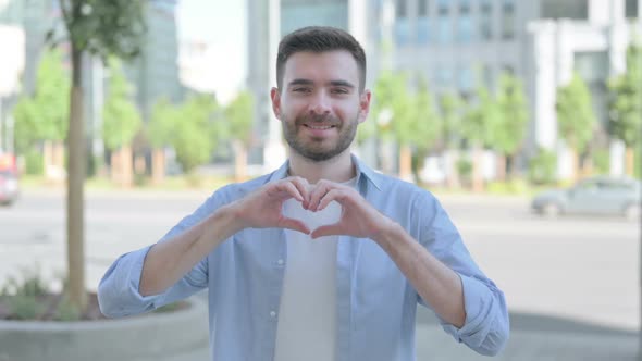 Loving Young Man Showing Heart Shape By Hands